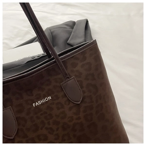 Gros plan d'un sac cabas léopard avec logo FASHION blanc et texture en cuir synthétique