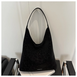 Dettaglio borsa hobo in pelle scamosciata nera con testo stampato e tracolla moderna