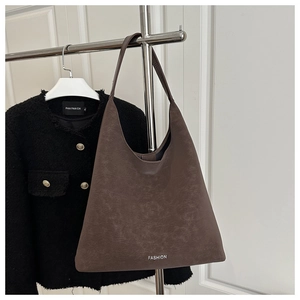 Détail d'un sac cabas rétro en cuir marron foncé avec logo FASHION blanc imprimé