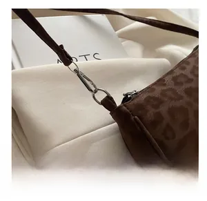 Macro detail of silver metal hook and leopard print faux suede fabric texture