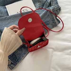 Mini sac bandoulière rouge à pois pour filles montrant l'espace de rangement intérieur