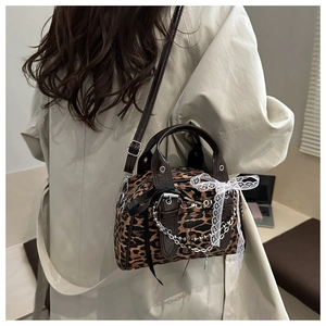 Detail of leopard print handbag with white lace bow and silver metallic chains