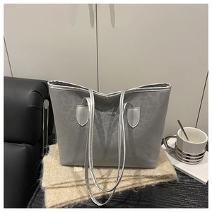 Détail d'un grand sac cabas imprimé léopard gris avec fines anses et texte Fashion