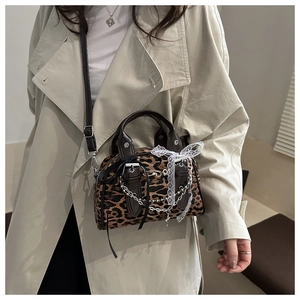 Dettaglio borsa leopardata con catene argentate e decorazione fiocco in pizzo bianco