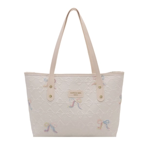 Beige quilted tote bag with colorful embroidered bows and leather shoulder straps