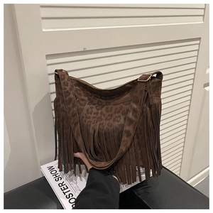 Detail of leopard print suede tote bag with long fringe tassels and gold hardware buckle