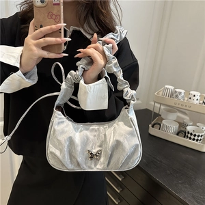 Metallic silver ruched underarm bag with butterfly metal accent and woven shoulder strap