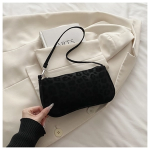 Détail du mini sac baguette à imprimé léopard noir avec fermeture éclair argentée