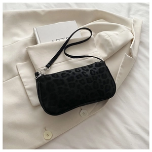 Détail du sac baguette à imprimé léopard noir avec texture douce et boucles argentées