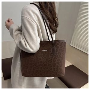Macro detail of the leopard print tote bag texture with fashion text and leather handles
