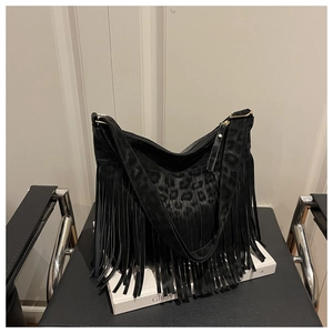 Detail view of large black leopard print suede tote bag with long leather fringes