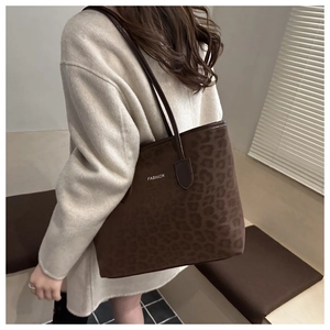 Sac fourre-tout léopard marron avec texte Fashion porté sur un manteau en laine beige