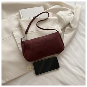 Détail du petit sac baguette bordeaux avec gaufrage léopard et un smartphone