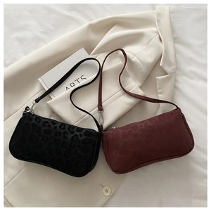 Détail des sacs baguette à motif léopard en noir et bordeaux avec texture animale