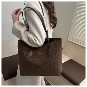 Detail van donkerbruine tote bag met luipaardprint, suède textuur en fashion-logo