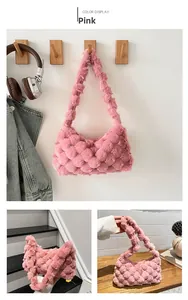 Detailed view of pink plush woven tote bag with soft spherical texture on wood hook