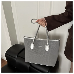 Détail du sac cabas léopard gris avec lanières argentées et texte de mode gravé