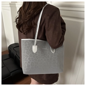 Détail du sac cabas gris à motif léopard avec texte FASHION et anses en cuir robustes
