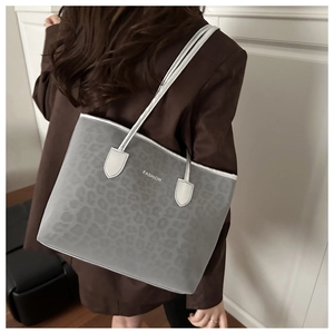 Détail d'un sac cabas léopard gris avec de longues anses et lettrage de mode chic