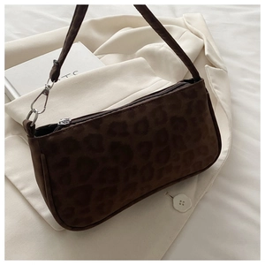 Détail du sac à bandoulière en daim léopard marron foncé avec un blazer crème