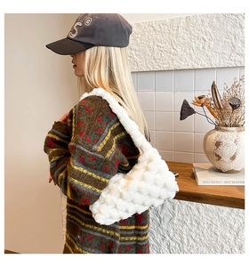 Detail of white plush shoulder bag featuring a soft cloud-like woven texture and fuzzy material