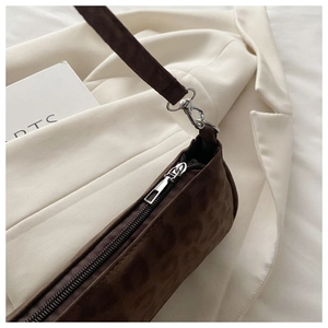 Détail du sac baguette en daim imprimé léopard avec finitions argentées chic
