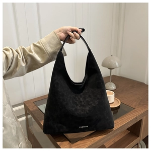 Détail du sac hobo en daim noir avec lettrage Fashion blanc et poignée en cuir