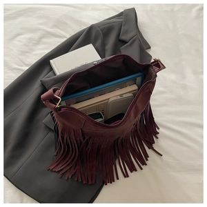 Interior view showing the large capacity of a burgundy fringe crossbody bag with gadgets
