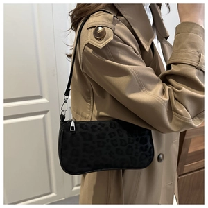 Detail of dark leopard print texture and silver metal buckles on a baguette bag