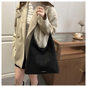 Dettaglio borsa shopper in camoscio nero opaco con testo Fashion in un ambiente domestico