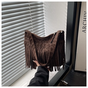 Detail of dark brown suede tote bag with leopard print, long fringe and wide strap