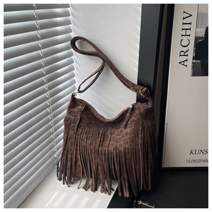 Detail of vintage leopard print crossbody bag with long tassels on a window sill
