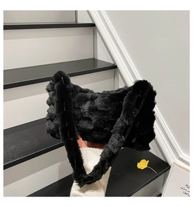 Detail of black faux fur shoulder bag with textured checkerboard pattern and plush strap
