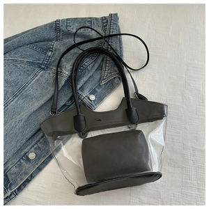 Vue détaillée du sac cabas transparent en PVC avec pochette noire sur tissu denim