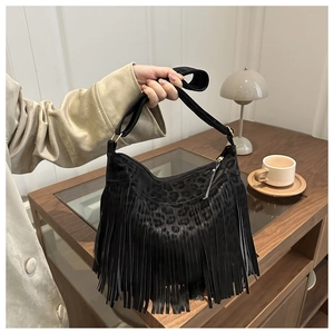 Close-up of black fringe shoulder bag with leopard embossed texture and stylish tassels