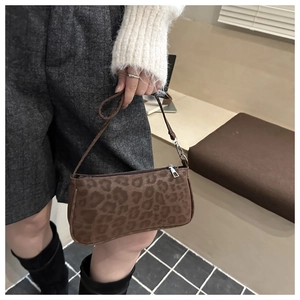 Close-up of brown leopard print baguette bag with soft texture and silver zipper detail