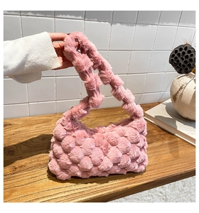 Close-up of the plush pink woven handbag texture on a wooden desk for winter fashion