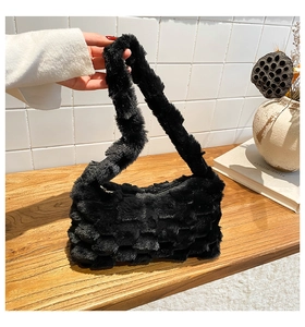 Close-up of fluffy black faux fur texture on a minimalist small square shoulder bag