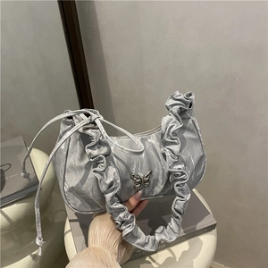 French style silver crescent underarm bag with pleated edges and metal butterfly charm