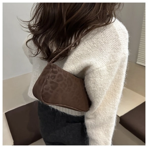 Brown leopard print baguette underarm bag paired with a soft white knit sweater