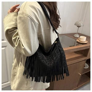 Detail of black fringe tote bag featuring leopard print and sleek gold zipper accents
