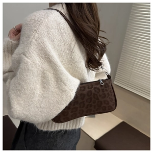Close-up of small brown leopard print shoulder bag with silver metallic buckles and thin strap