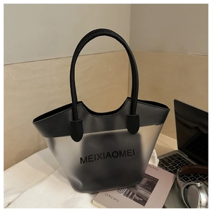 Détail du grand sac cabas en PVC avec anses en cuir et logo MEIXIAOMEI sur un bureau de travail