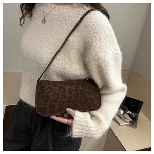 Detail of a chic leopard print shoulder bag with soft textured fabric in a winter setting