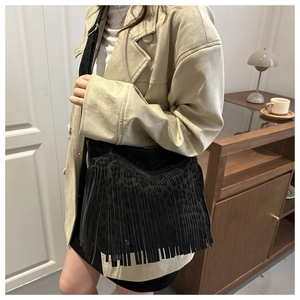 Detail of black bohemian tassel shoulder bag with leopard print and adjustable strap