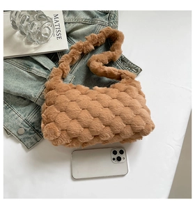 Detail view of brown plush crossbody bag with textured woven faux fur and long strap