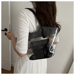Detail of transparent PVC tote bag with black leather inner pouch and shoulder strap