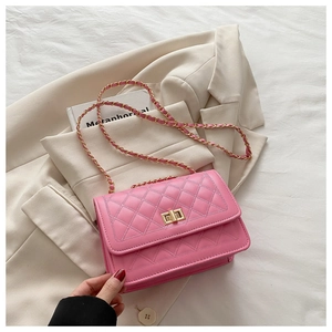 Detail of pink quilted handbag with gold square twist lock and leather chain strap