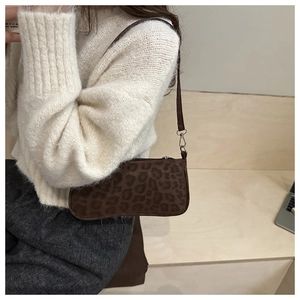 Brown leopard print baguette bag detail showing suede texture and slender shoulder strap
