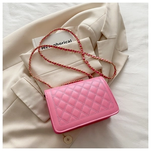 Detail of pink quilted crossbody bag with gold chain strap and fine leather texture